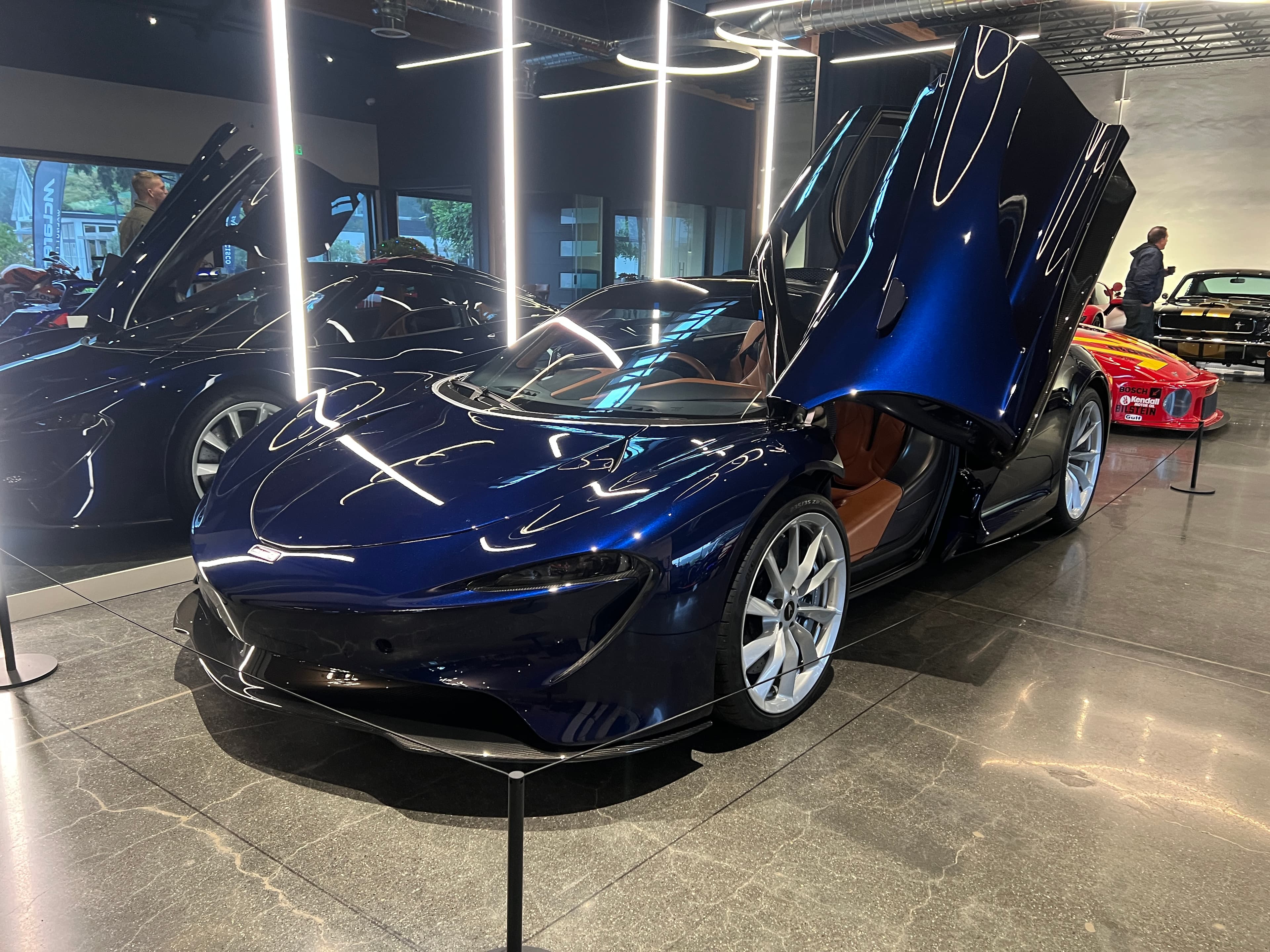 Dark blue McLaren Speedtail with doors open in a showroom